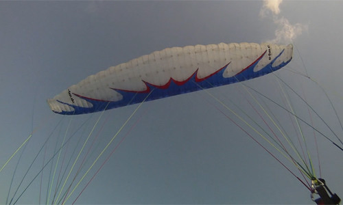 Parapente branco voando na velocidade mínima